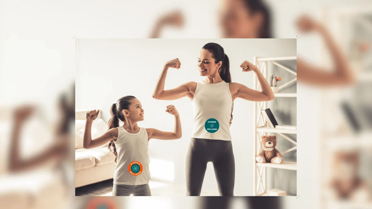 Séance de coaching à domicile Athomic Wellness : mère et fille en tenue sportive s’entraînent ensemble et montrent leurs muscles dans une ambiance familiale et motivante