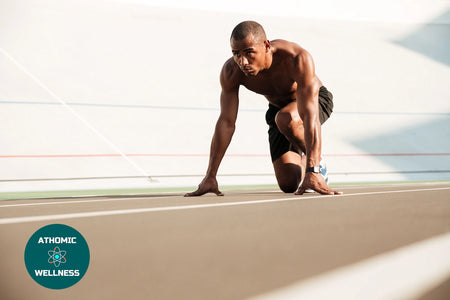 Athlète en position de départ sur une piste de course pour illustrer la préparation athlétique Athomic Wellness